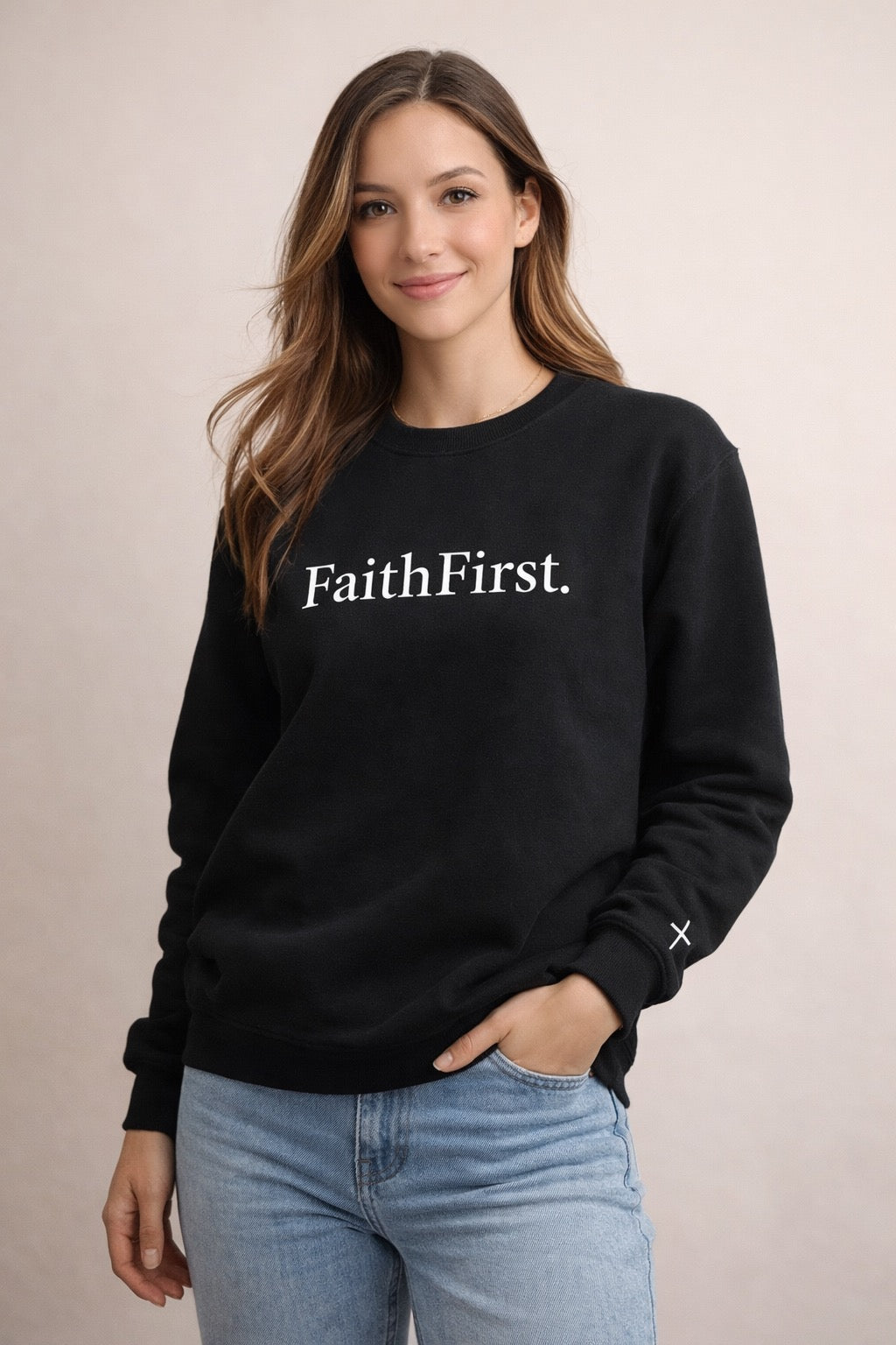Woman wearing a black sweatshirt with 'Faith First' text on a beige background