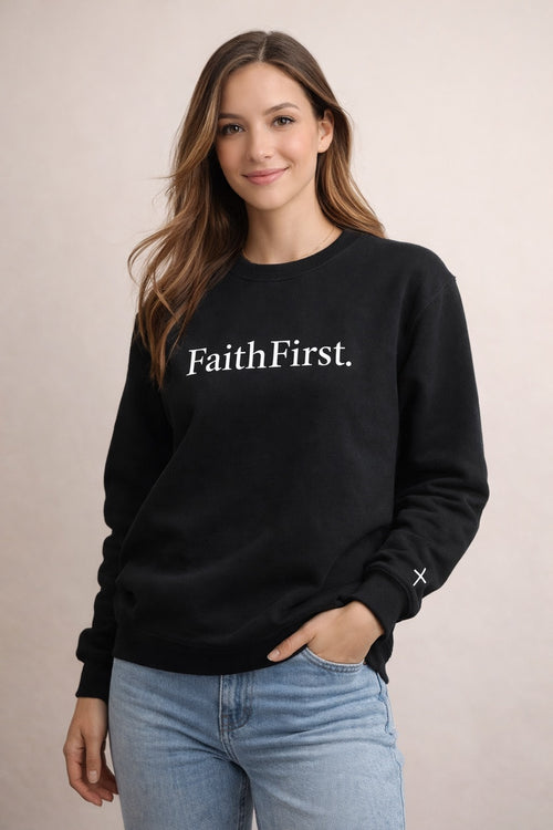 Woman wearing a black sweatshirt with 'Faith First' text on a beige background